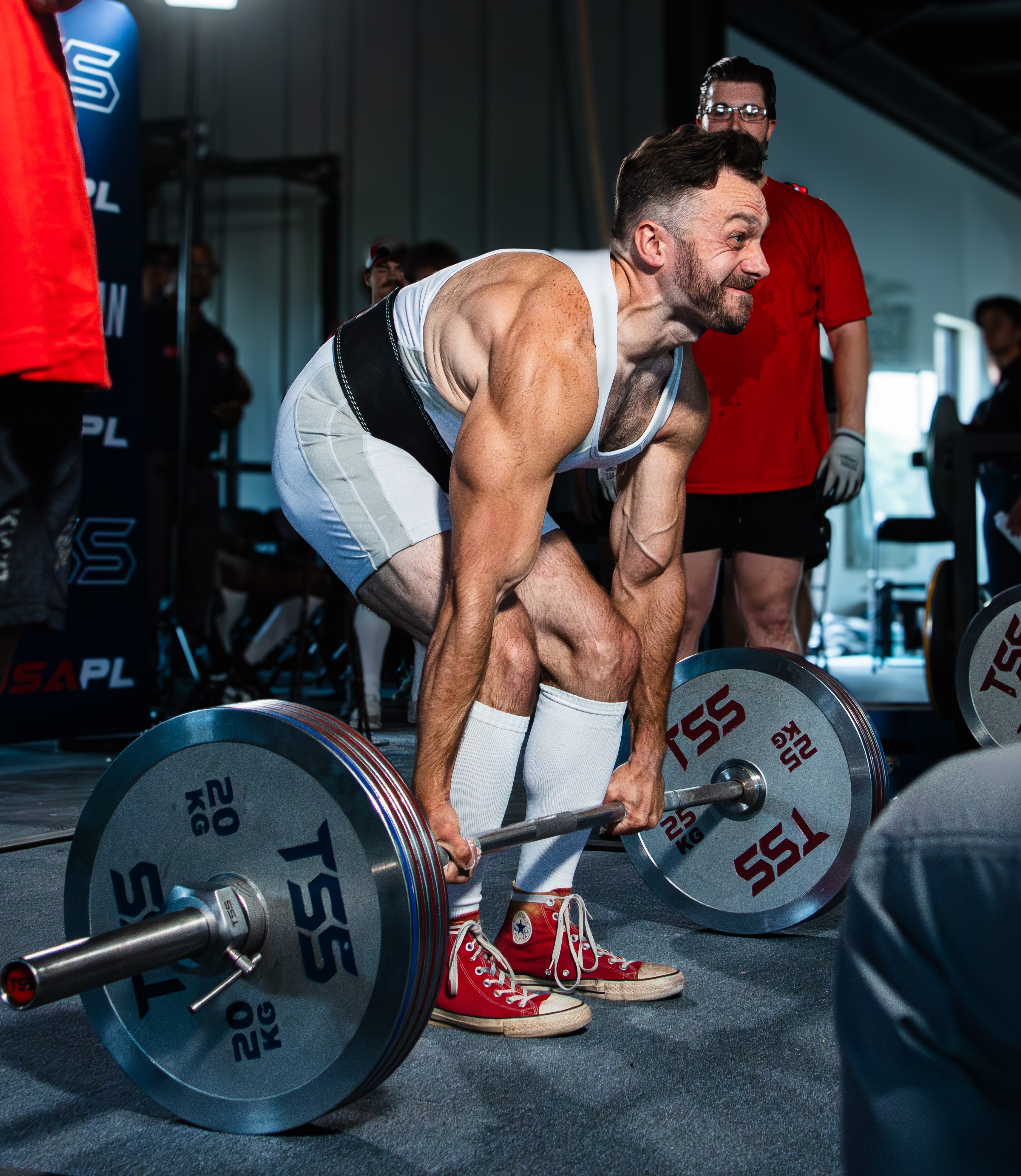 Lifter in mid-deadlift in an industrial gym setting